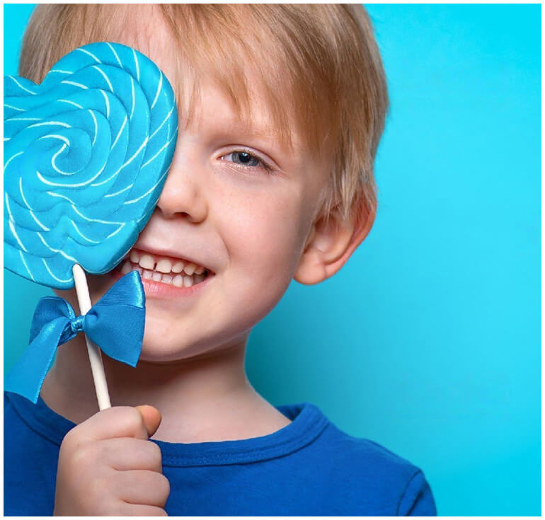 stock image of boy holding heart shaped lollipop
