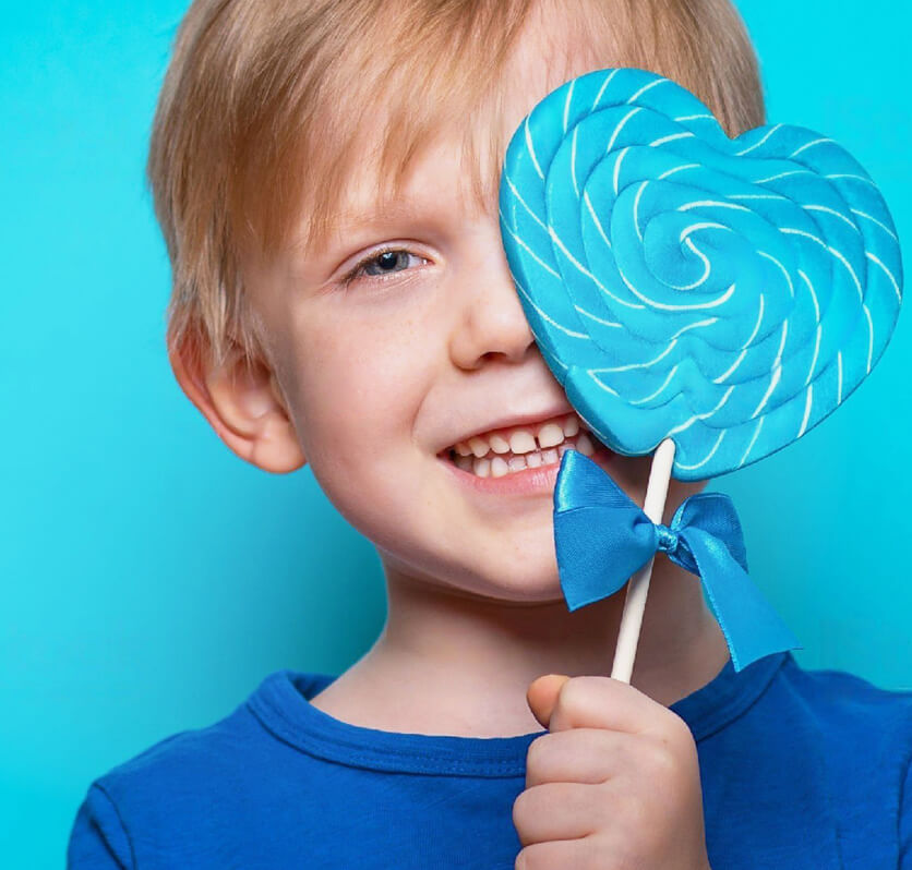 stock image of boy holding heart shaped lollipop