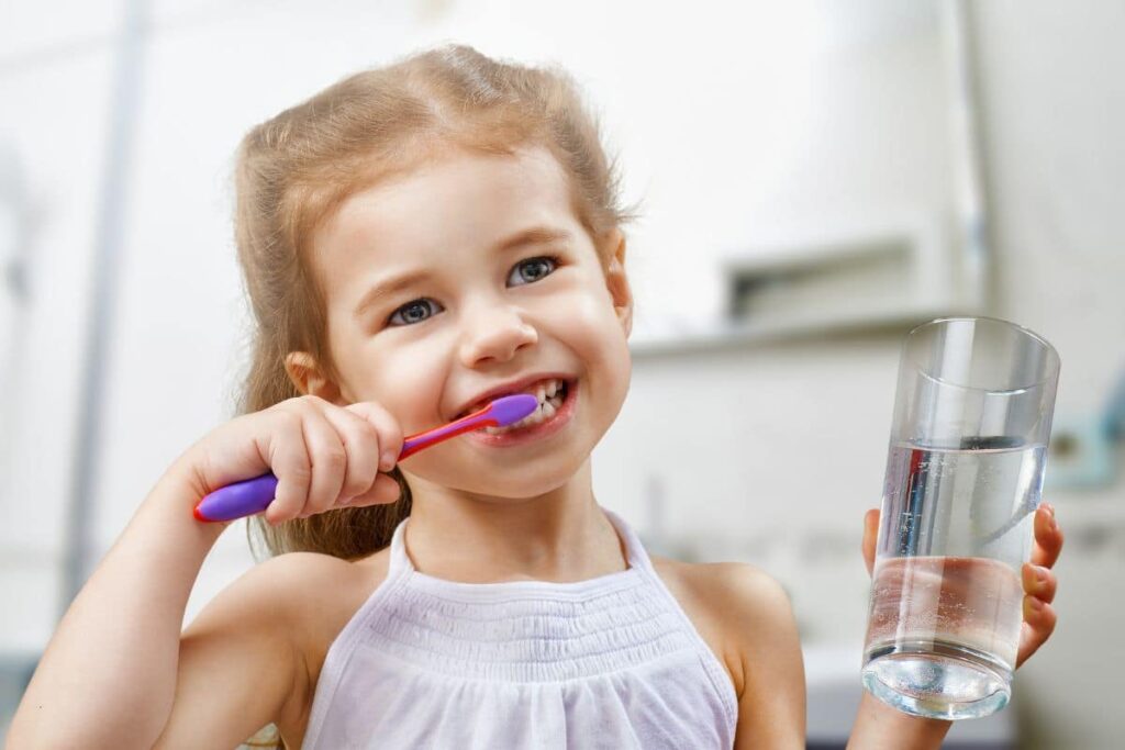 Child brushing teeth with proper dental hygiene techniques