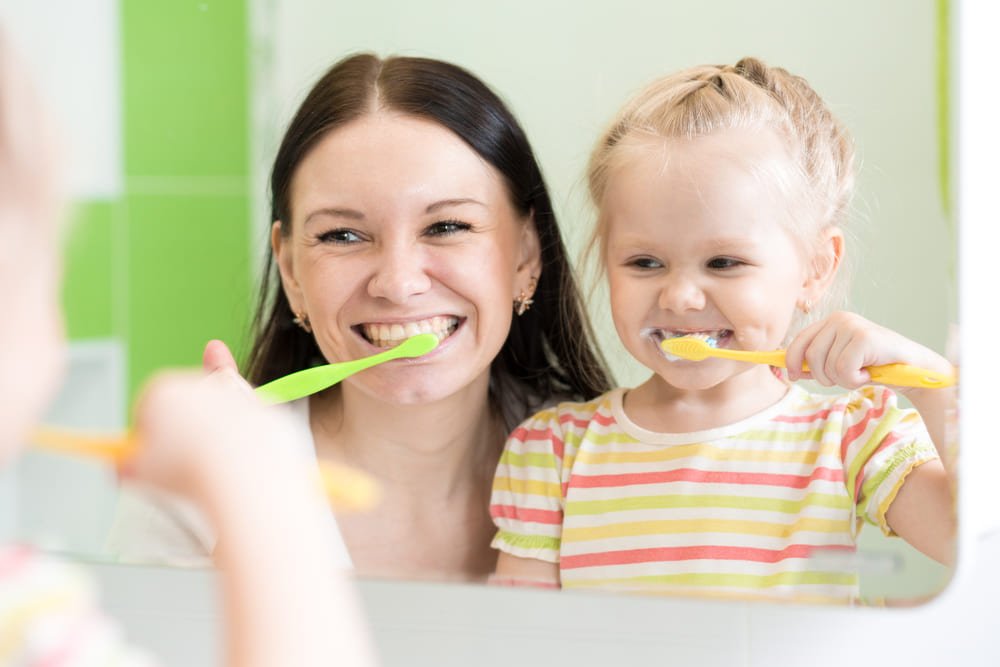 Adults and kids following dental hygiene tips