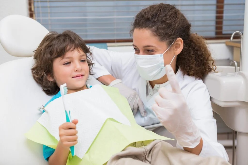 Pediatric dentist demonstrating dental hygiene tips