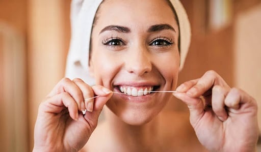 flossing teeth to remove plaque buildup